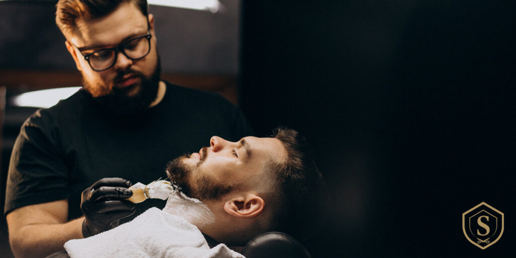 barbero realizando corte de barba a cliente